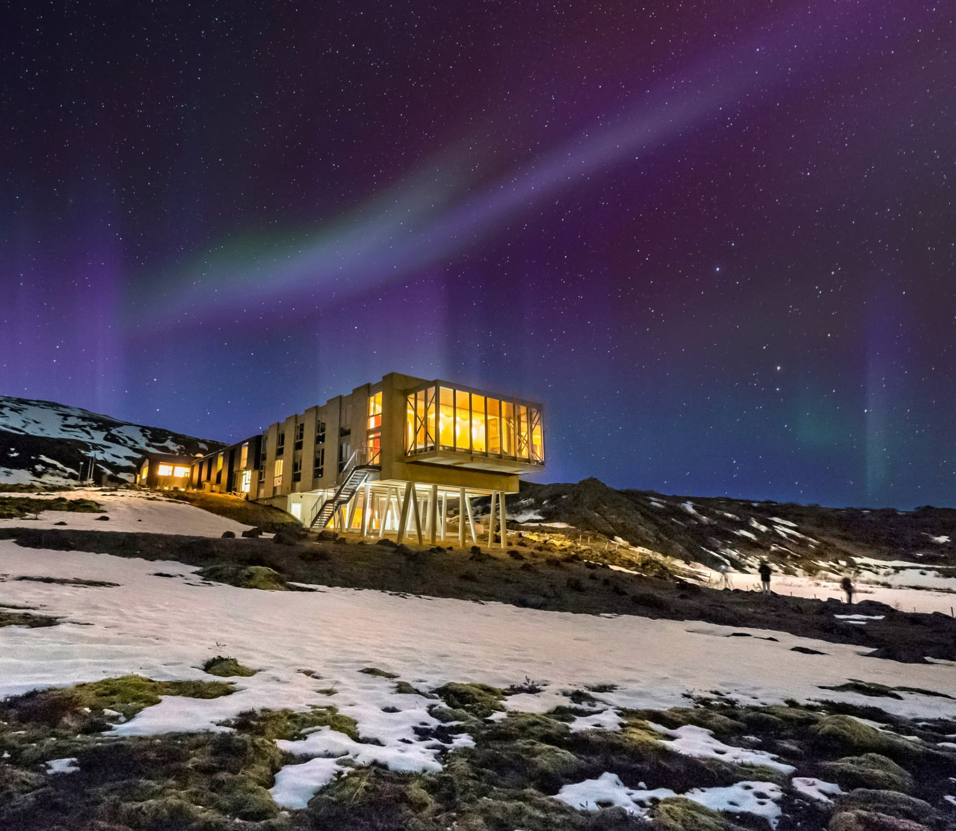 ION Adventure Hotel cantilevered above a snow-dusted hillside under the northern lights at night